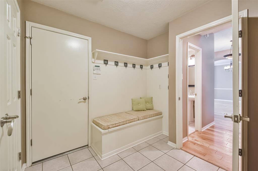 The utility room features this great bench with custom cushions, shelf and hooks–perfect for keeping everything you need readily available and organized.
