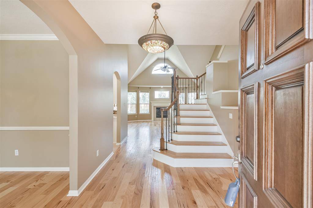 Your welcoming entry way features stunning hand-scraped wood floors, wood stairs with wrought iron balusters and a Tiffany-style chandelier.