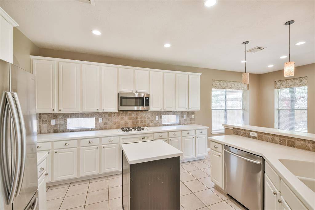 Plenty of cabinet and counter space here! And the window backsplash brings in natural light and is the perfect place for your kitchen herbs.