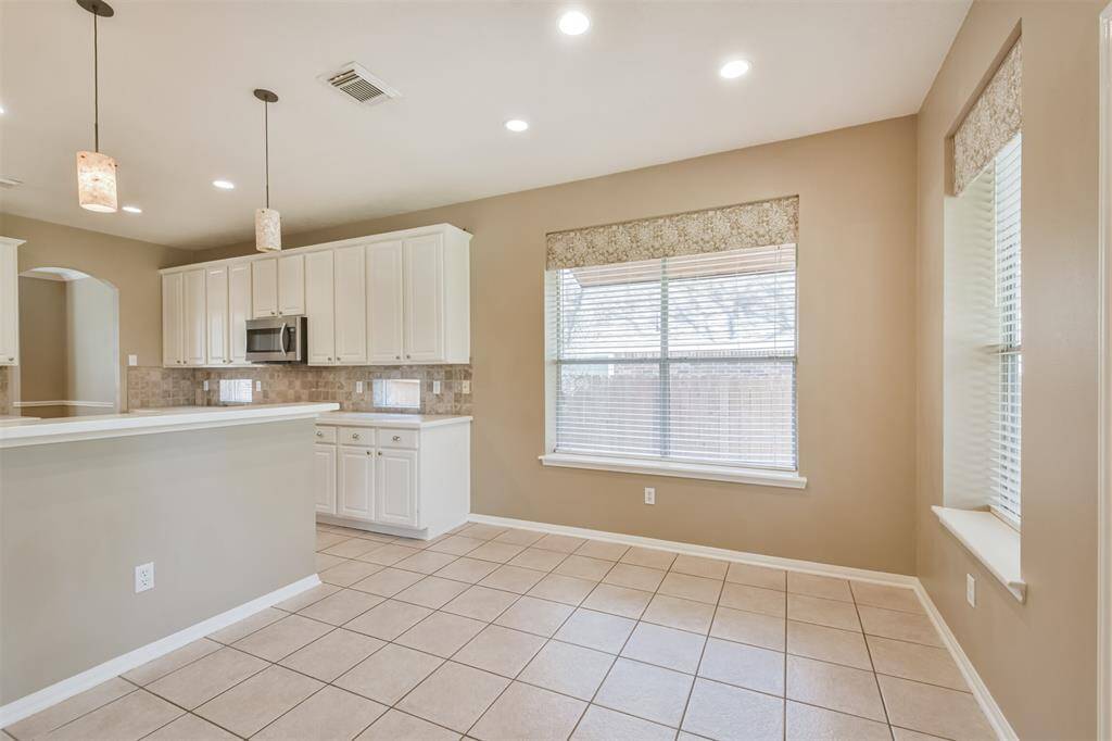 The breakfast room is spacious and surrounded by oversized windows overlooking the back yard.