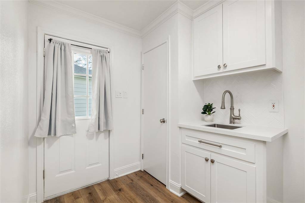 Covered walkway to the garage leads to this utility room with a closest, storage space, and a sink - such a unique find for Spring Shadows. Washer/Dryer are in this area as well.