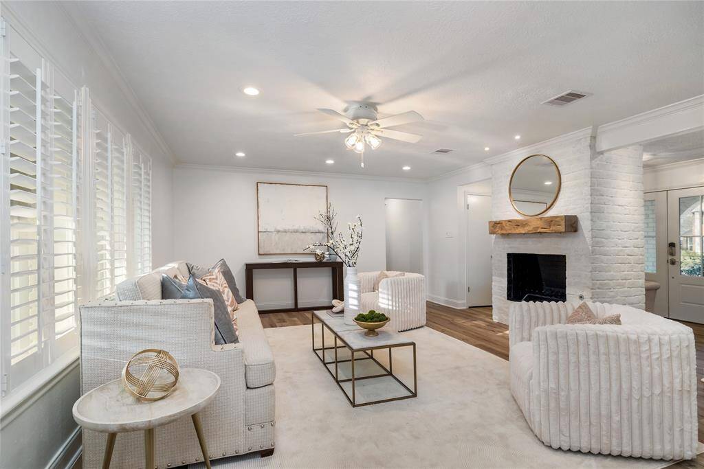 Cozy living room centered around the fireplace with windows overlooking the backyard.