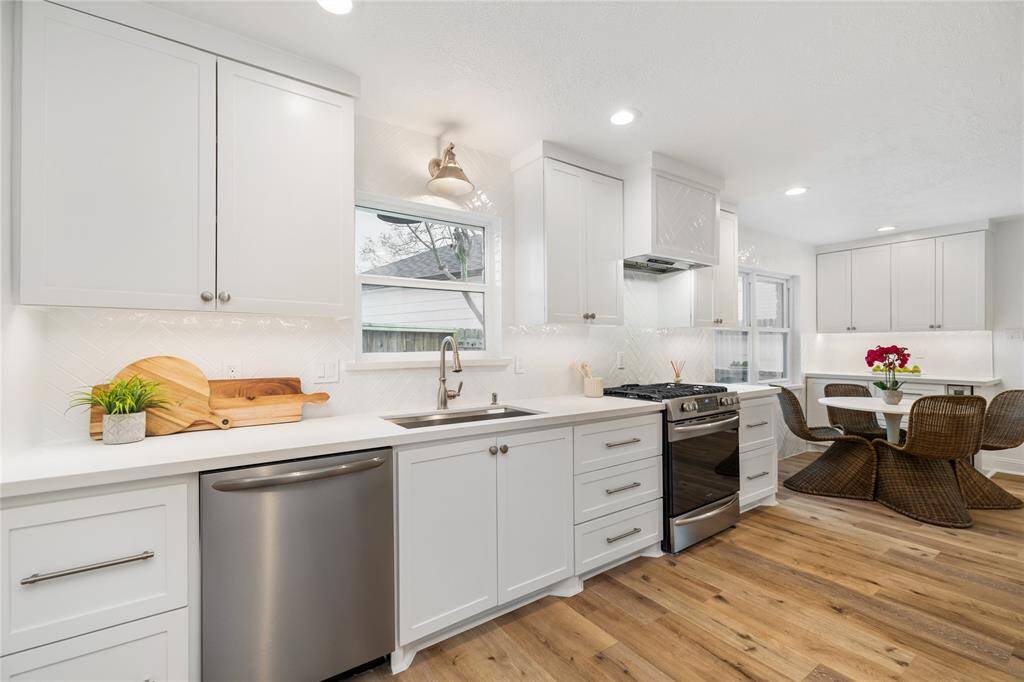Gorgeous updated kitchen with custom cabinets that go to the ceiling, Quartz counters, backsplash that also goes to the ceiling, large farmhouse sink, and serving space with wine fridge.