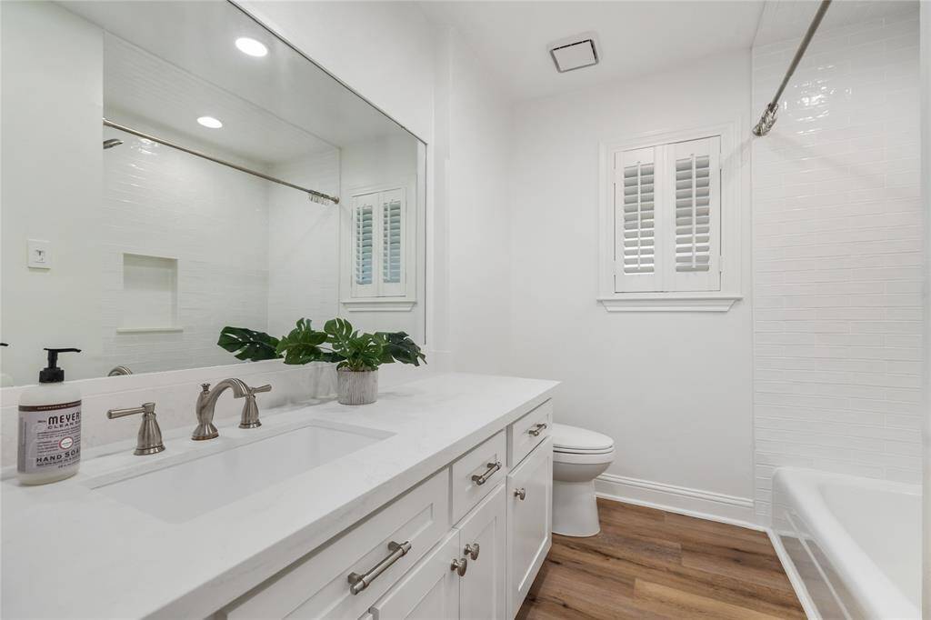 The hall bath is gorgeous with ample storage, subway tile surround for the tub, LVP flooring, and a linen closet.