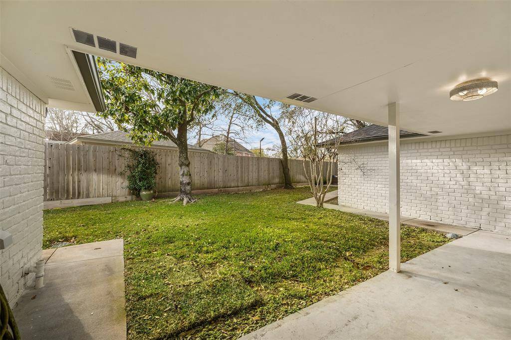 Back outside, you will find this covered patio off the kitchen. It's a great place for a grill and more seating.