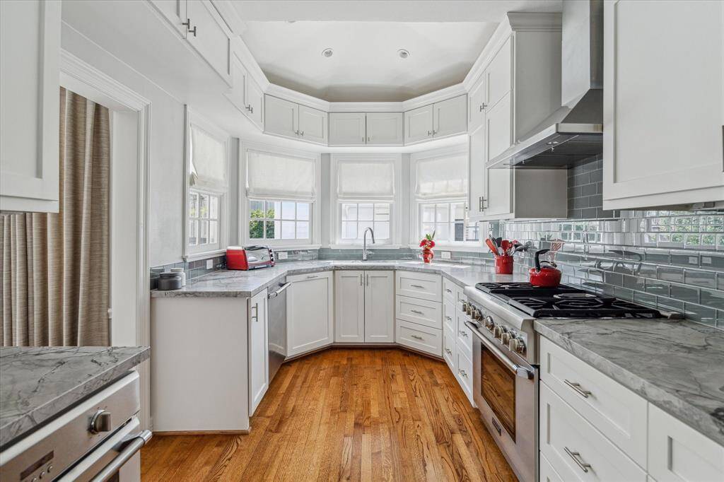 Leathered quartz countertop, steam oven, gas range with oven and vent hood.