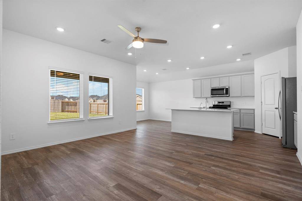 Large windows provide beautiful backyard views and fill the space with natural light, making it ideal for family gatherings and entertaining.