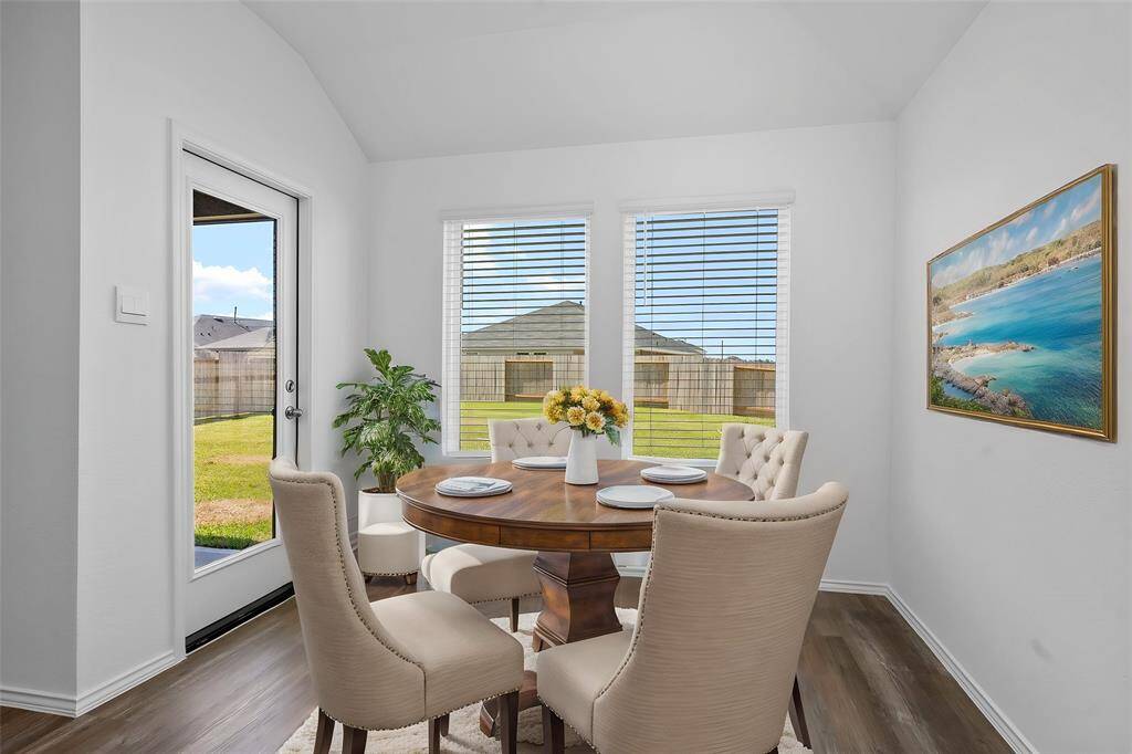 A bright and inviting dining space with high ceilings, large windows, and backyard access, creating a seamless indoor-outdoor flow for entertaining. **Photo is Virtually Staged to show how it would look like**