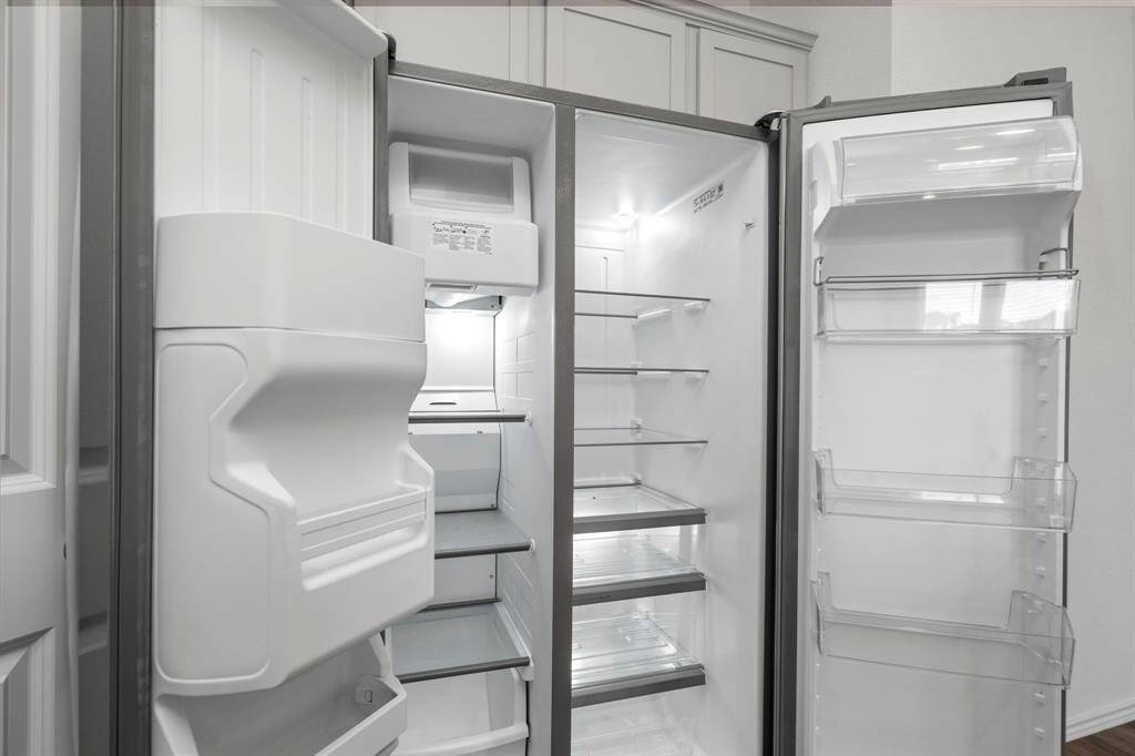 This spacious side-by-side stainless steel refrigerator is included with the home, offering ample storage and a built-in ice and water dispenser.