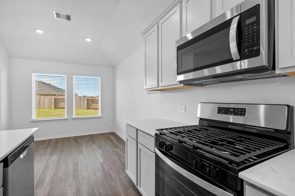 A sleek and modern cooking area featuring a freestanding gas range with a stainless steel finish and a built-in microwave for easy meal prep.