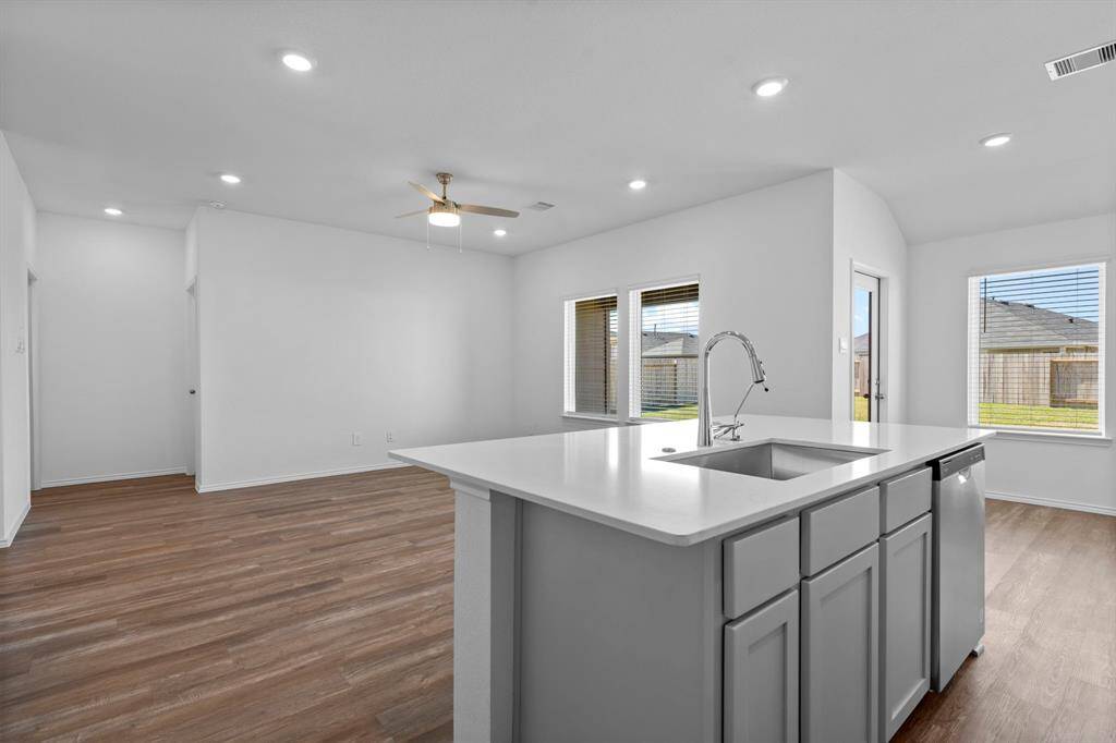 An open and airy layout with large windows that provide plenty of natural light, offering seamless flow between the kitchen, dining, and living areas.