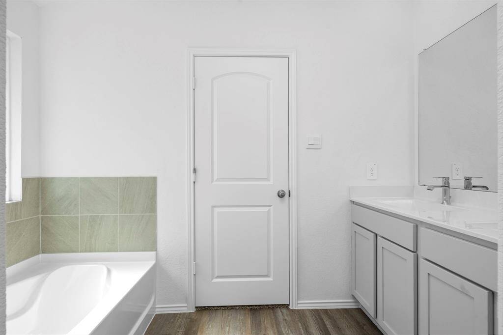 A spa-like retreat with a dual-sink vanity, a deep soaking tub, and modern finishes, offering both style and functionality.