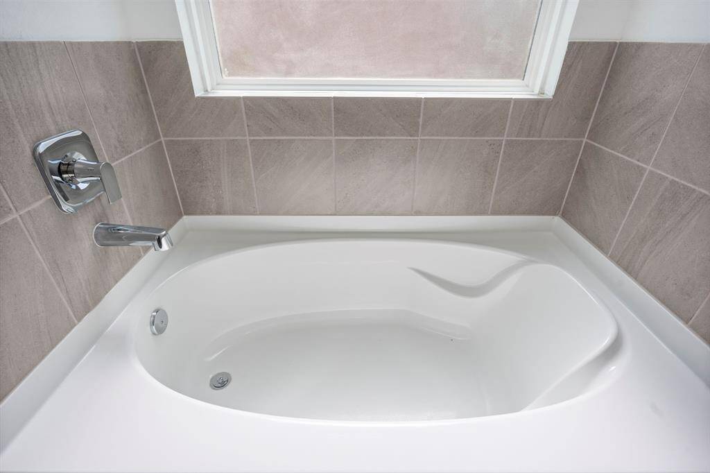 Relax and unwind in this deep soaker tub, surrounded by stylish tile and a large window that brings in natural light while maintaining privacy.  Yes, we have those bubble bath people covered also!