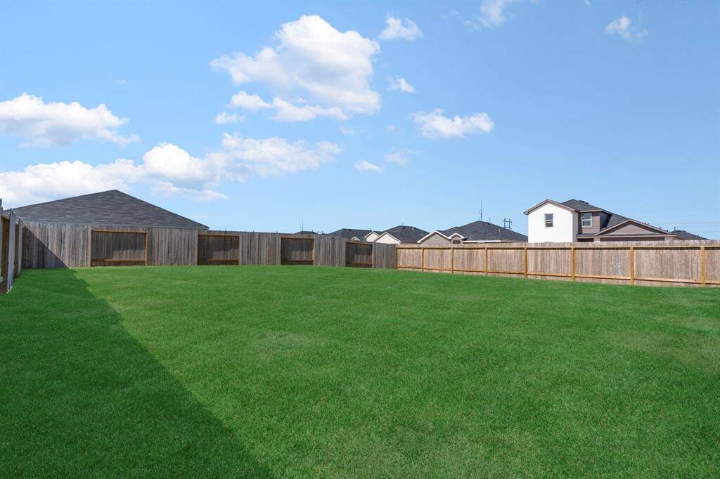 This fully fenced backyard provides plenty of space for outdoor activities, offering privacy and room to relax.