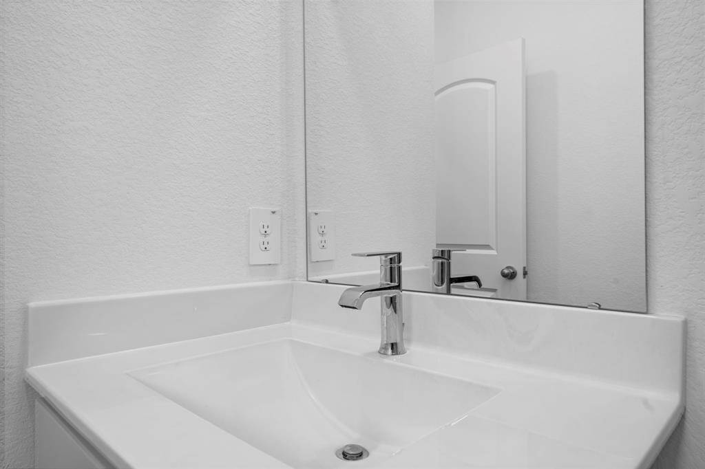 A sleek, modern vanity with a quartz countertop and contemporary fixtures adds a touch of luxury to the home's spa-like bathrooms.
