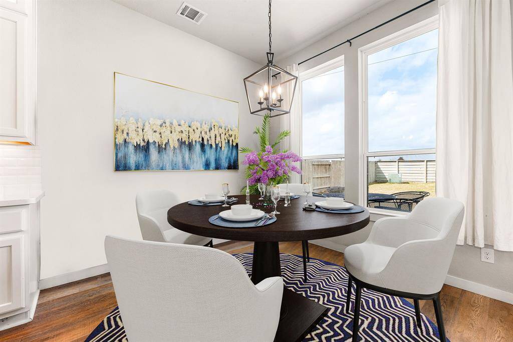 This lovely breakfast area is perfect for starting the day out on the right foot.  This space showcases custom paint, high ceilings, hanging pendant light, recessed lighting, large window adding to the ample natural light in the kitchen, and beautiful wood style flooring. *Virtually Staged