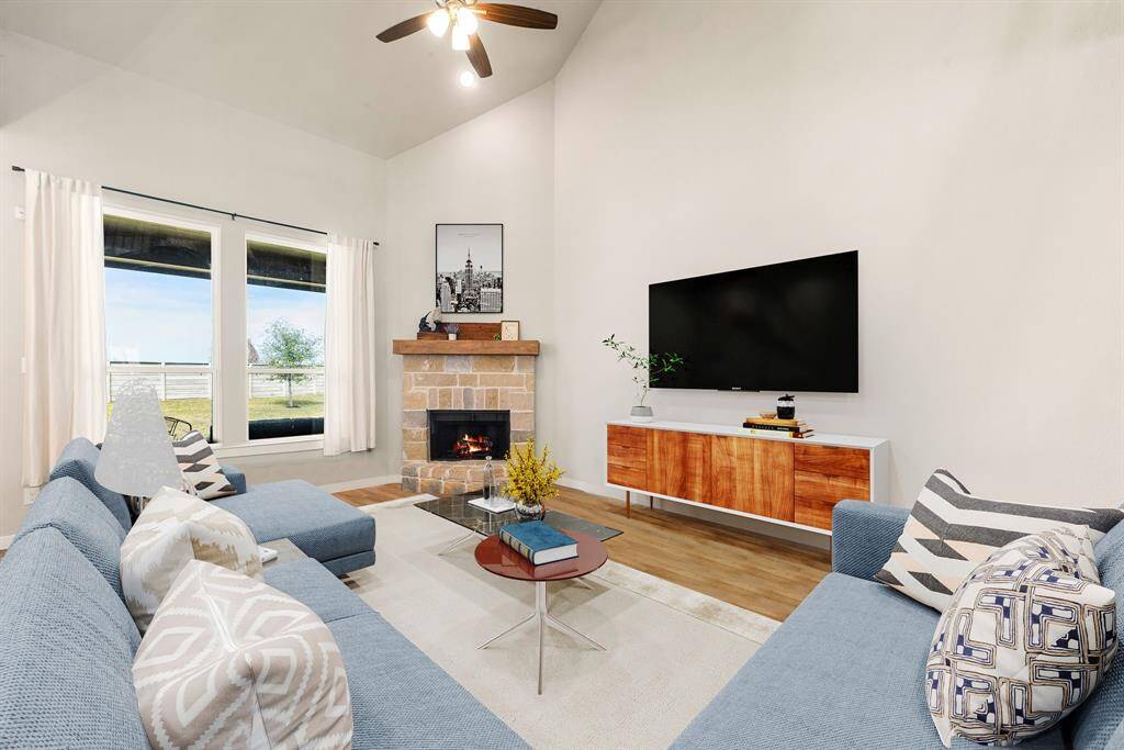 This living room is more like a GREAT room featuring a stunning fireplace with mantel detailing, custom paint, soaring high ceiling, recessed lighting, dark stained ceiling fan, and an amazing wall of windows providing a lovely view of your backyard to keep an eye out on the kids or pets playing. *Virtually Staged