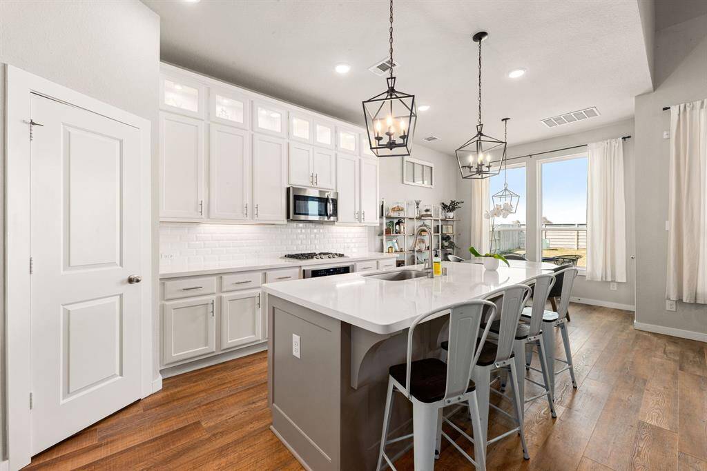 This kitchen is by far any chef’s dream! This spacious kitchen features large windows, high ceilings, light cabinets, quartz countertops, SS appliances, modern tile backsplash, recessed lighting with additional custom pendant lighting, extended counter space, quartz kitchen island and space for breakfast bar and a walk-in pantry all overlooking your huge family room.