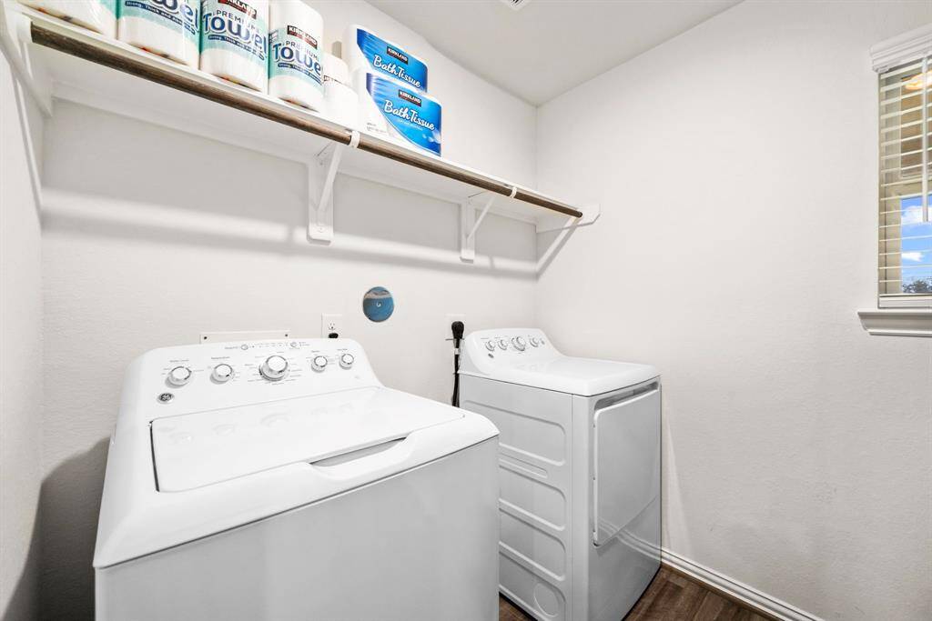 Enjoy a laundry ROOM (not a closet!). Built in storage, as well as additional shelving/storage on the right that's not visible.