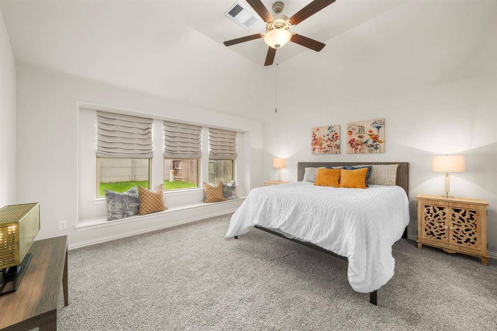 Welcome to the primary bedroom suite, freshly painted and with brand new carpet. Even with this king size bed, you still have plenty of room for larger furniture. Features include Custom Roman Window Shades, and a built-in window bench that offers a great reading or relaxation nook.