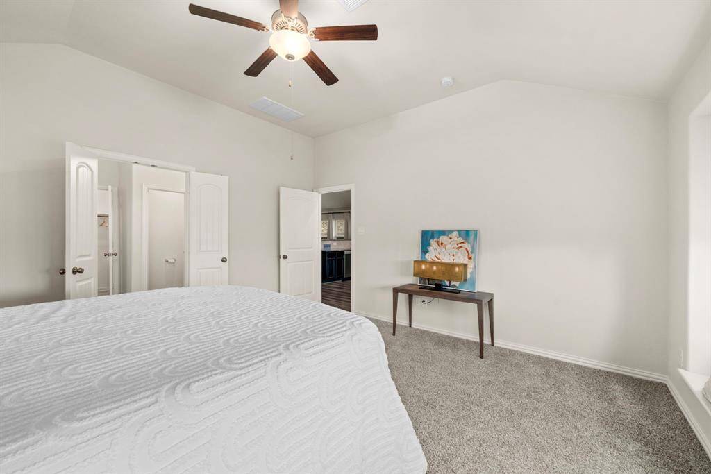 Alternate view of the large primary bedroom. The double doors on the left lead to the en-suite bathroom and walk-in closet.