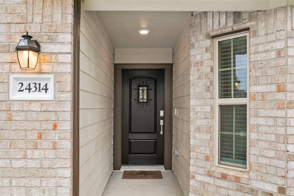Covered entry with stately door and smart lock.