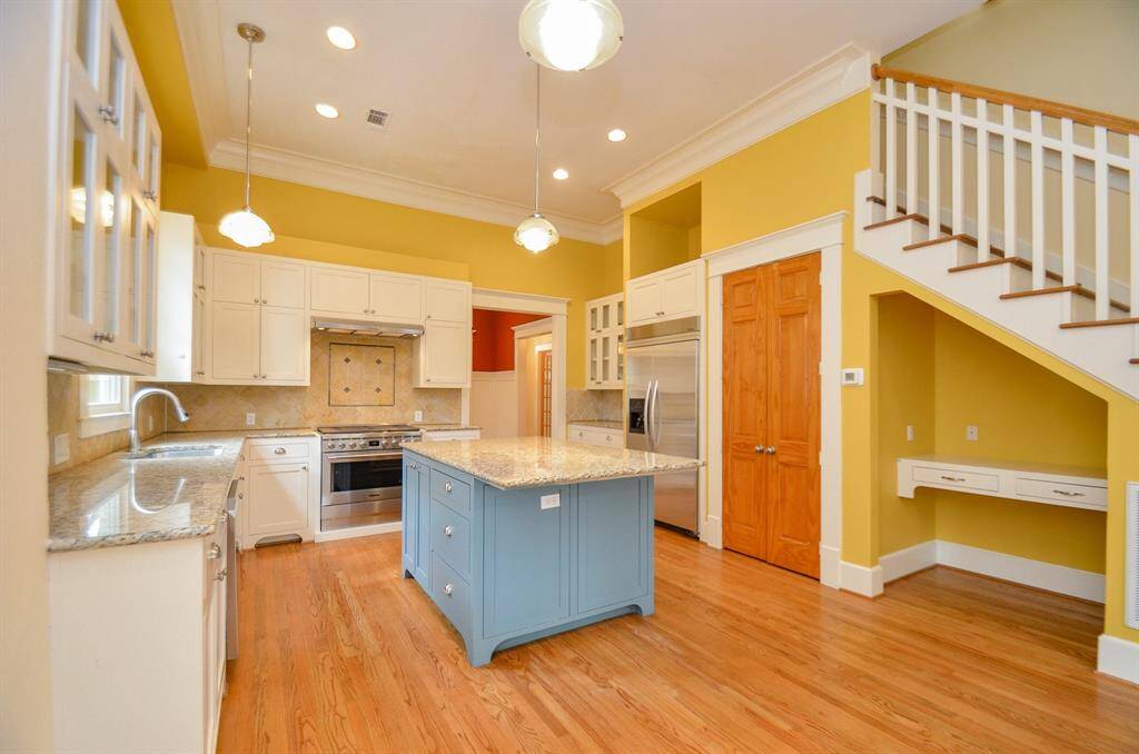 View of the kitchen including the desk area under stairs.
