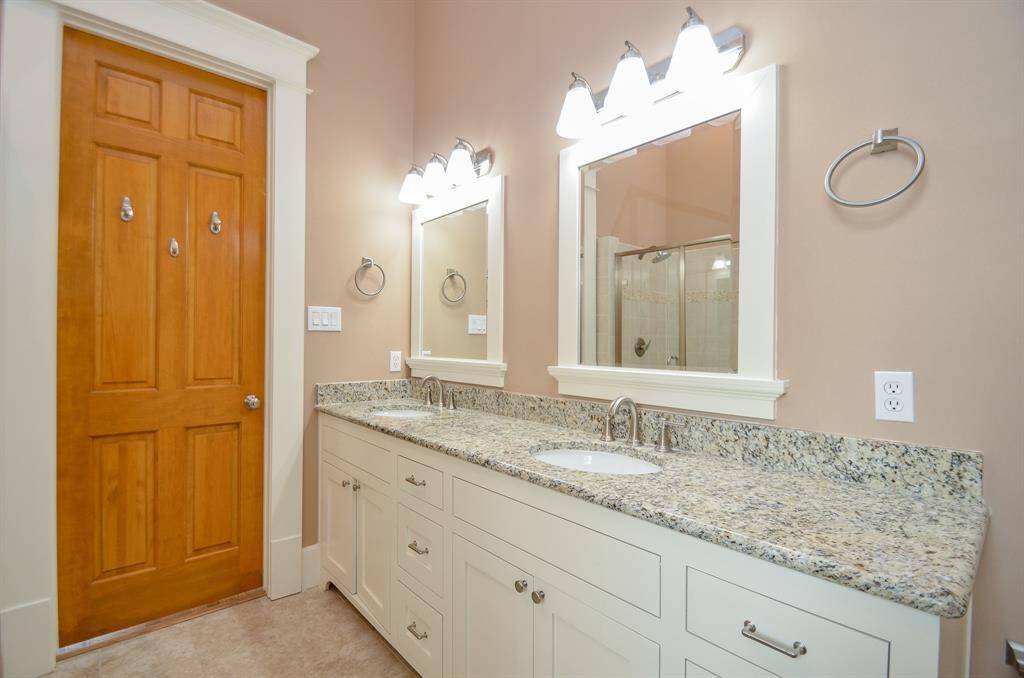 Principal bath with double sinks and stone counter top.