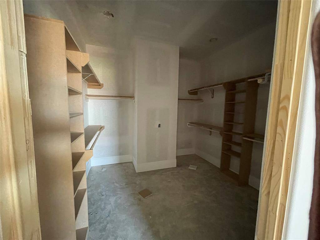 Primary bedroom walk-in closet with lots of space and shelving!