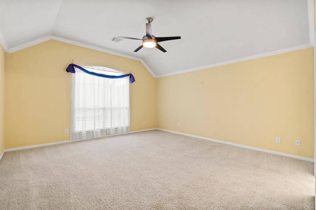 This is a cozy breakfast nook neutral walls and tiled flooring. It features a window with a blue valance, allowing natural light to brighten the space. The ceiling fan adds functionality.