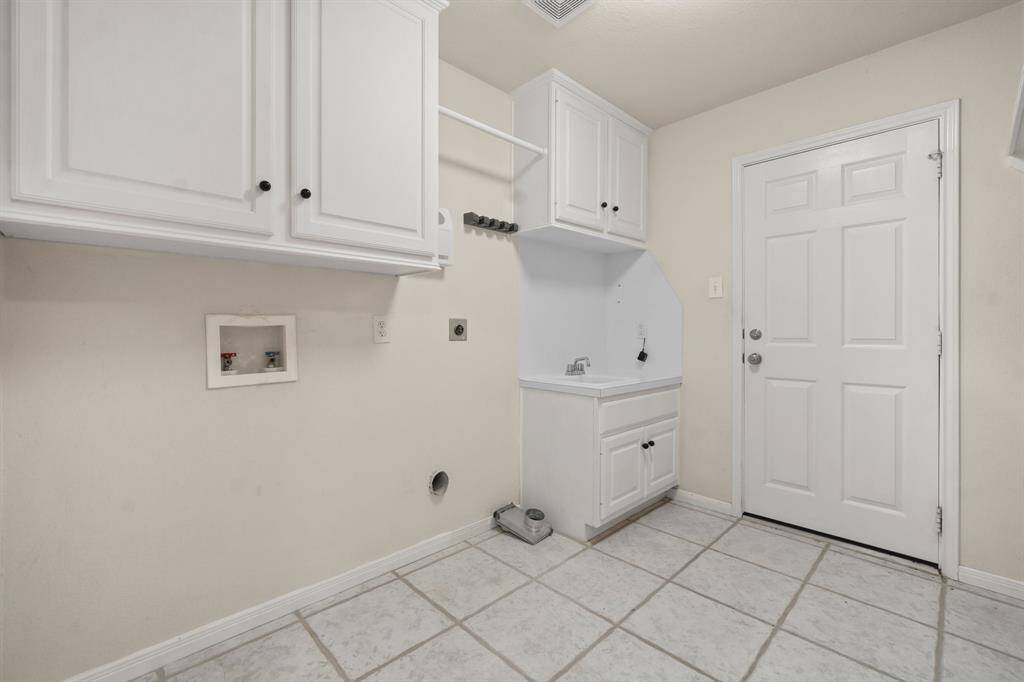 Spacious walk-in closet in Primary with ample shelving and hanging space, featuring tiled flooring and bright lighting for easy organization.