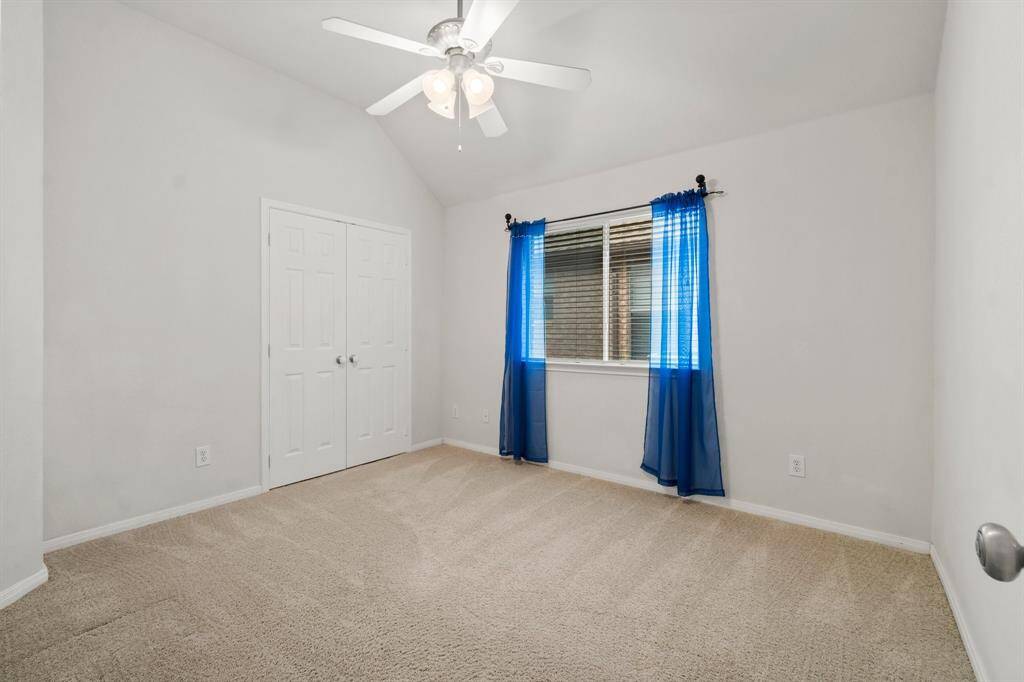 Large laundry room with white cabinetry, tiled flooring, sink, and hook-ups for appliances. There's a door leading outside, providing convenient access.