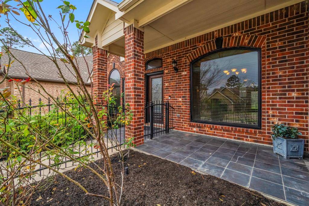 Charming brick home with a welcoming front entrance, manicured lawn, and landscaped bushes. The arched windows and neutral trim add character, while the paved walkway and iron fence provide a stylish touch. Perfect for buyers seeking curb appeal and a cozy feel.