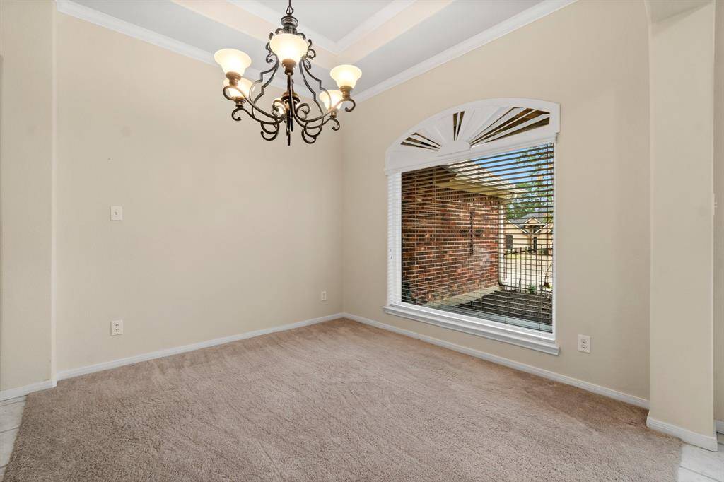 The spacious office layout with large arched windows offers plenty of natural light, and elegant French doors lead to the main foyer and formal dining area.