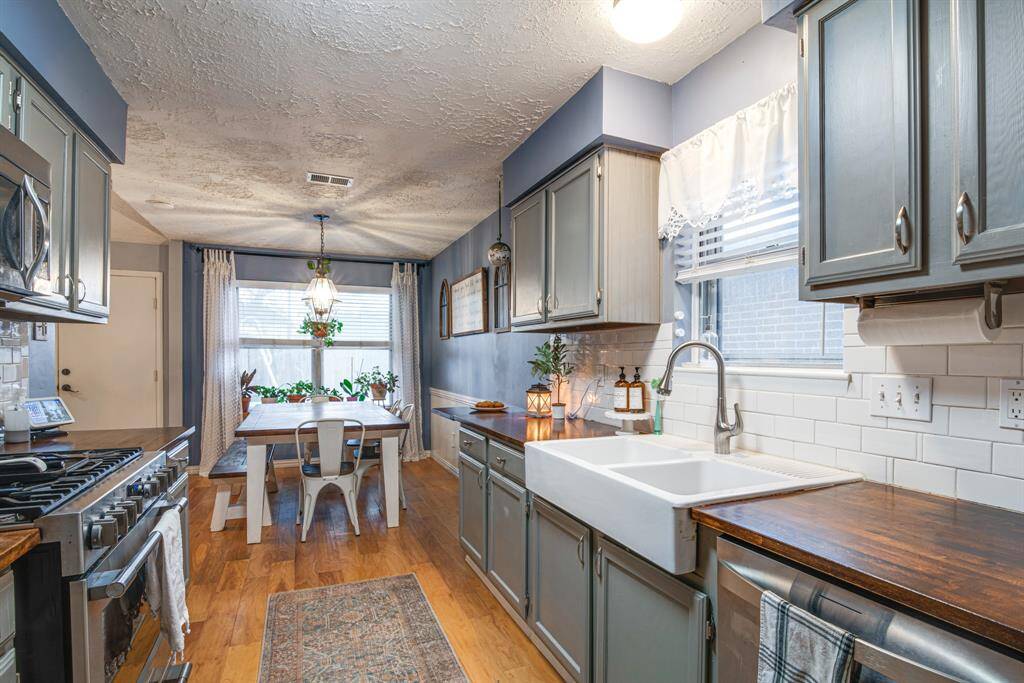 Cozy kitchen with a farmhouse sink, wooden countertops, and modern appliances.