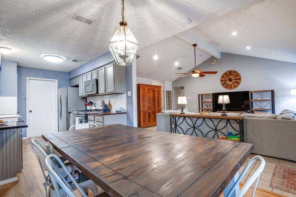 Open-concept kitchen and living area with vaulted ceilings.