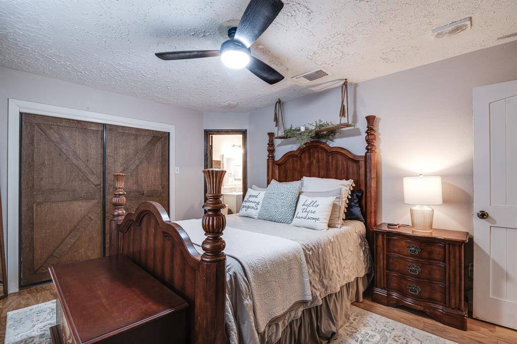 Master room has a ceiling fan, modern lighting, and barn-style closet doors, creating a warm and inviting atmosphere.