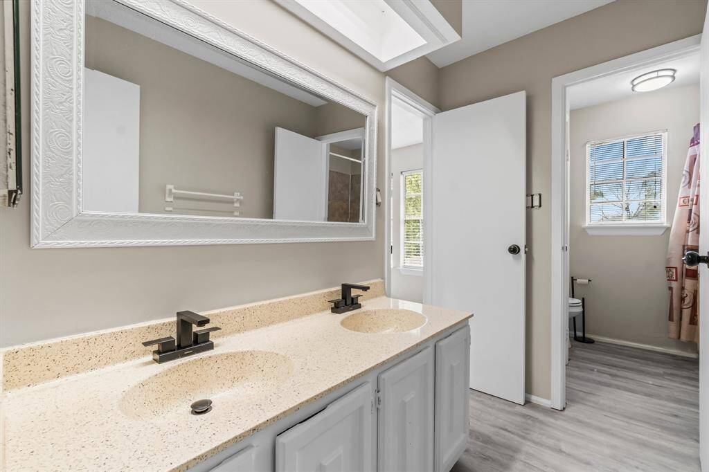 Secondary bath with 2 sinks and new flooring.