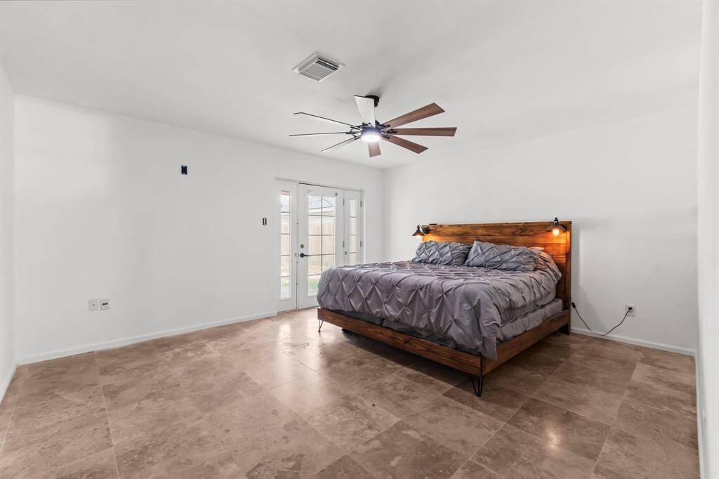 Primary bedroom has new paint and tile flooring with direct access into the backyard.