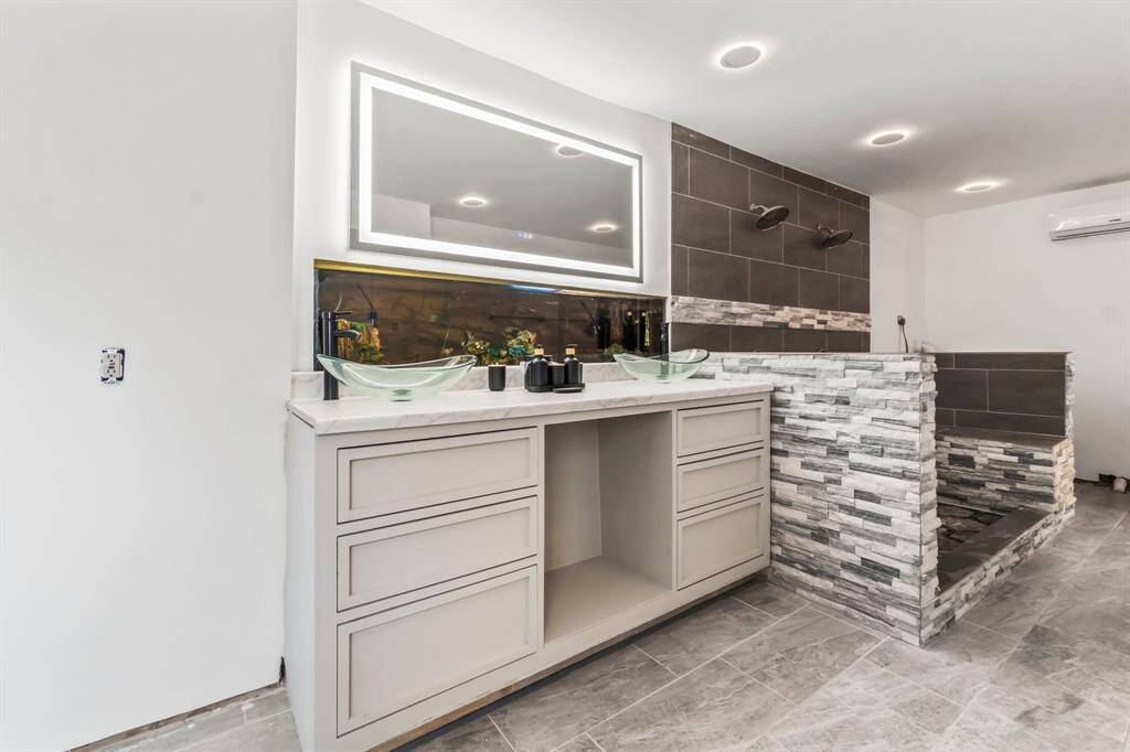 Totally reimagined en suite bath gives a spa like feel. 2 sinks, spa like shower and lighted mirror.