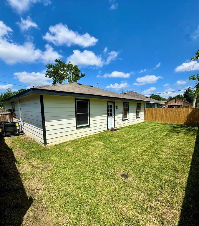 Backyard equipped with new AC and fencing.