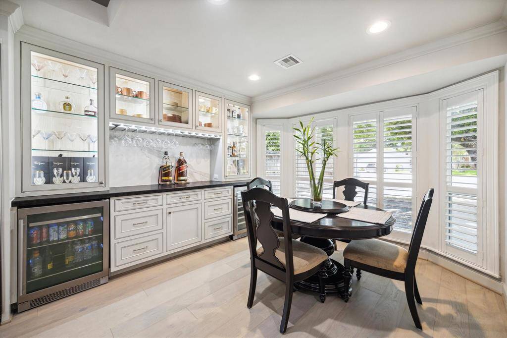 Just beyond the Front Room is a Breakfast Room doubles as a Lounge. The custom cabinets and leathered granite Butler's Pantry features a Beverage Refrigerator and a Wine Refrigerator, lighted glass cabinets with glass shelves, plus hanging space for your stemware. The Bay Window is clad in plantation shutters and has a view of the oak trees in the Front Yard.
