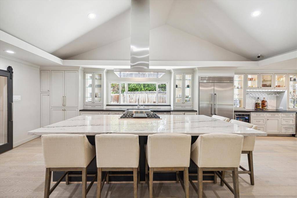 The Island features an oversized Quartz counter, a Thermador gas Range and a contemporary look, commercial grade Hood Vent.