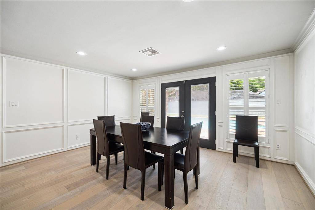 The Dining Room features block panelling, as well as glass paned French Doors that open to the pool.