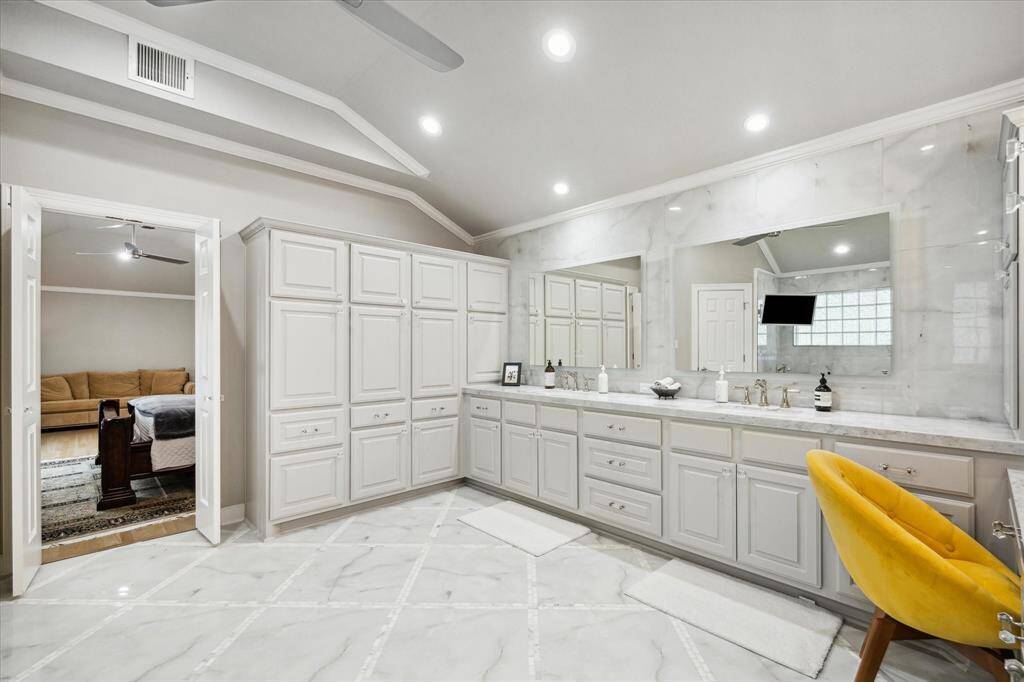 ...swoon-worthy Master Bath featuring glimmering quarzite, lighted mirrors, customs cabinets with dual vanities, and...