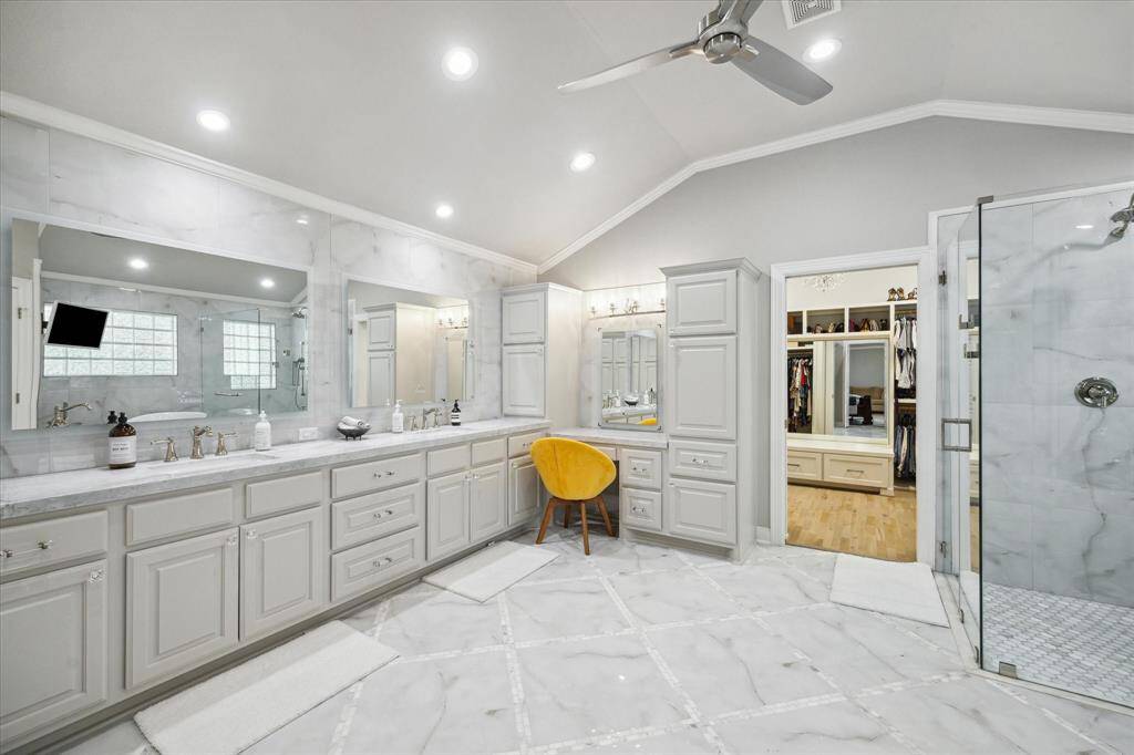 ...a seated Vanity with make-up lights, an oversized, marble clad Shower...