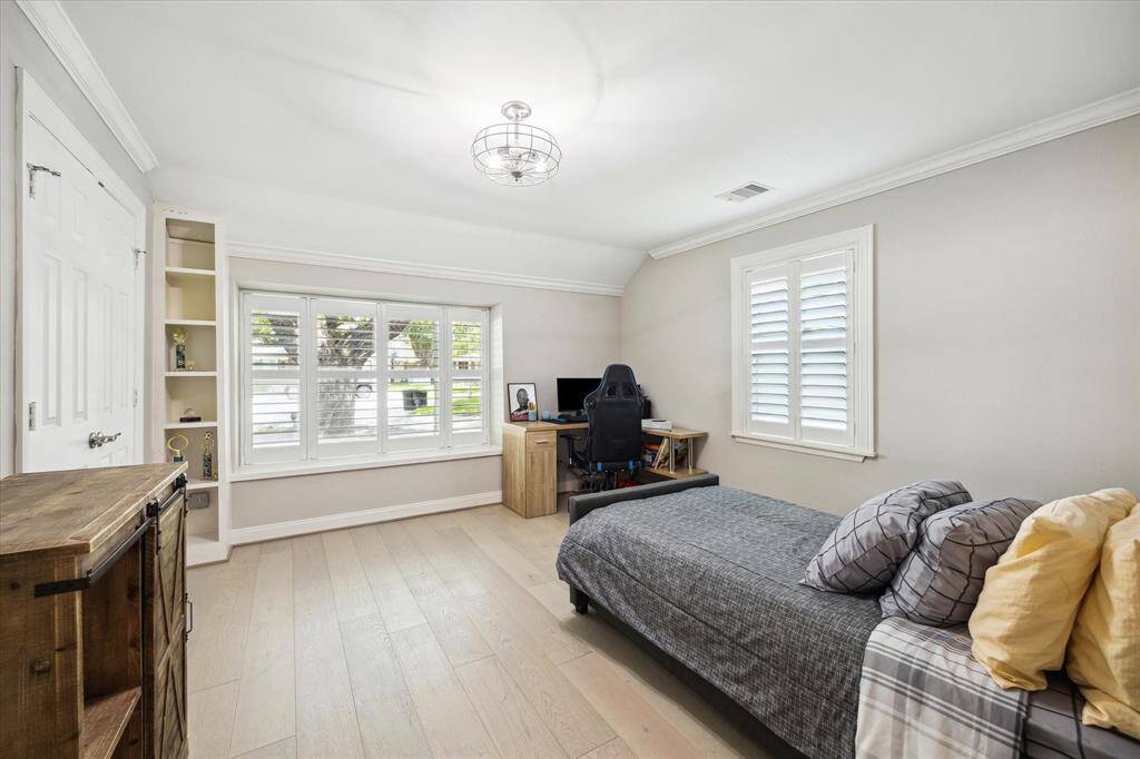 Bedroom Three has hardwood floors, crown moulding, plantation shutters and a nicely sized step-in Closet.