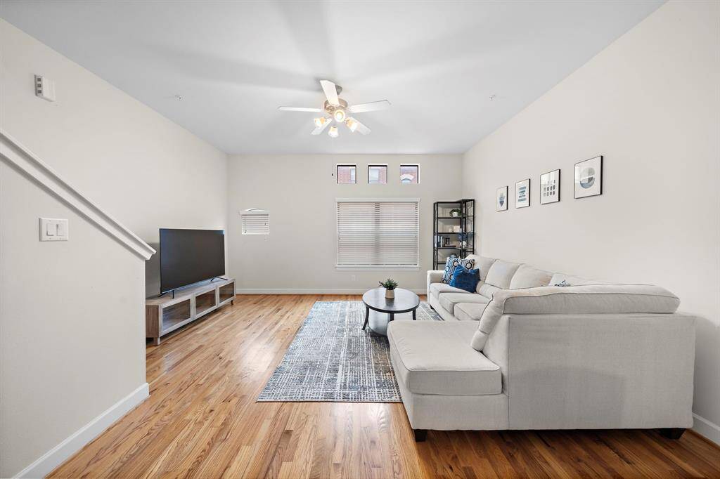 Hardwood floors unify the open living space, creating a flowing layout conducive to both relaxation and entertainment. Interior fan ensures comfort, while a neutral color palette provides a versatile backdrop for personal style.
