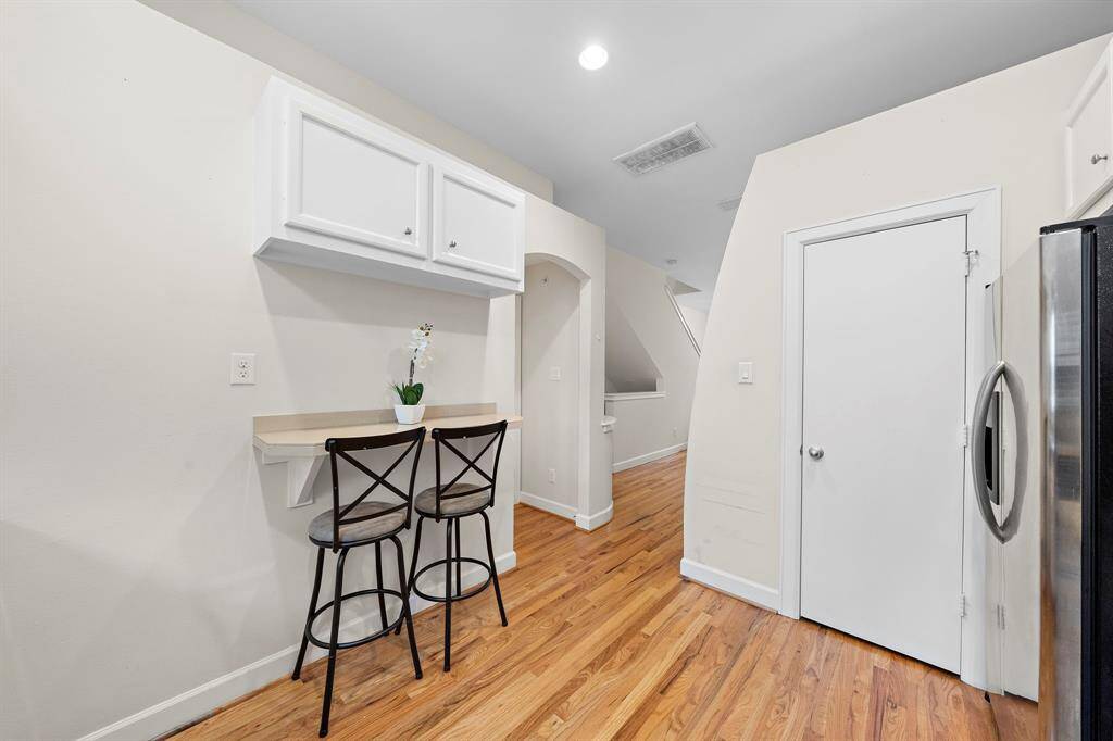 Breakfast bar exhibits extra seating and storage with classic cabinetry. Adjacent door opens to the side of the kitchen, conveniently located within the townhome.