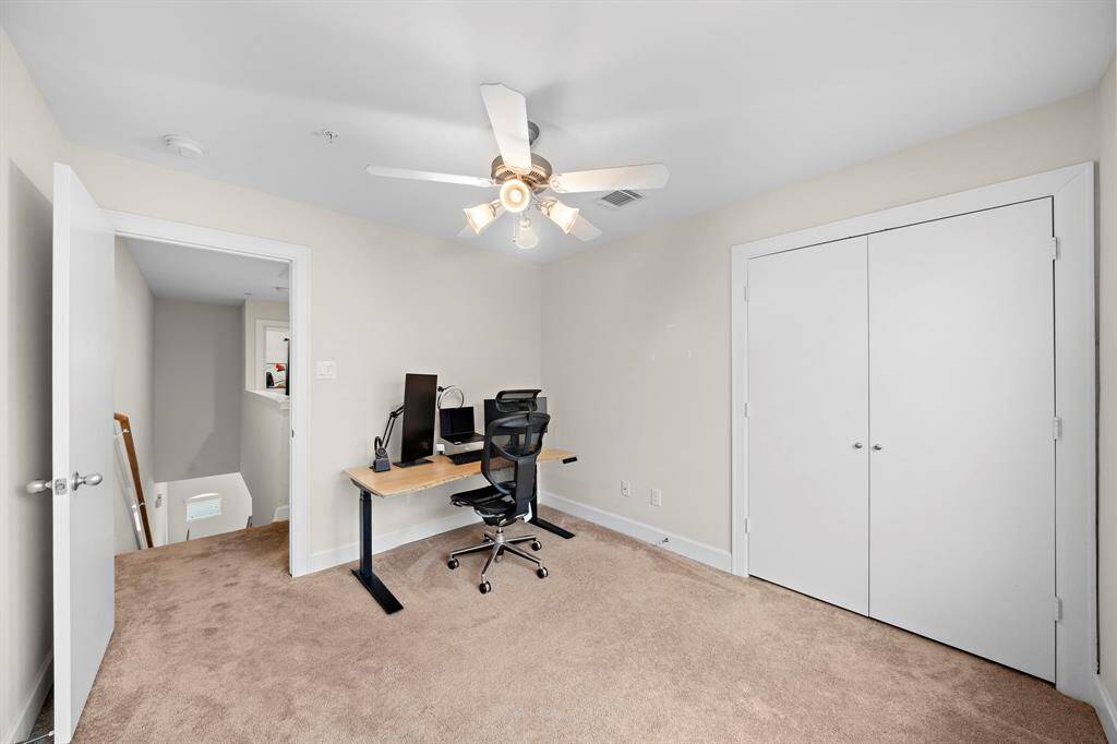 Turn this versatile space into a productive home office or guest room. Neutral carpeting adds warmth, complemented by a ceiling fan and a closet for storage.